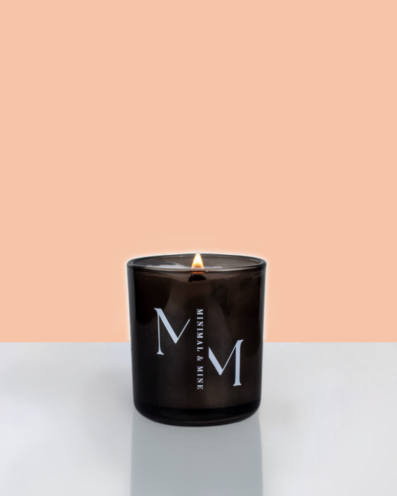 Peaches Candle Jar in sleek black glass, hand poured with natural soy wax and lit, showcasing vibrant summer vibes.