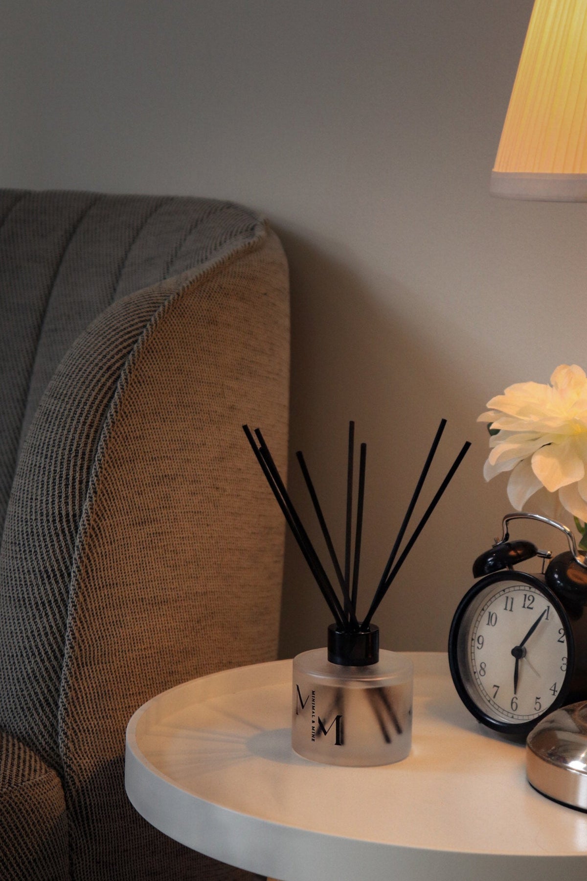 Small round table with diffuser next to a gray sofa