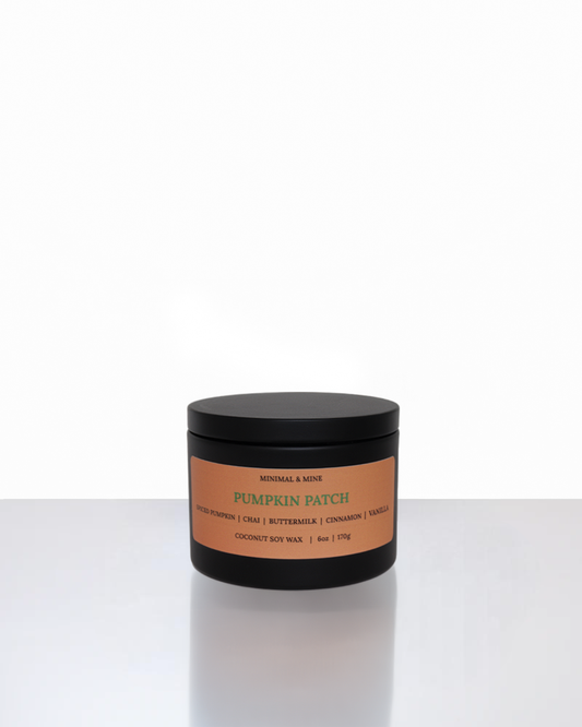 Pumpkin Patch candle in a black container, featuring warm spiced pumpkin chai, buttermilk, cinnamon, and vanilla.